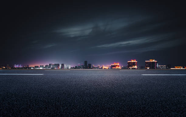 The night view of the city in front of the asphalt road